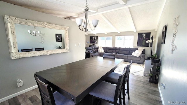 dining room with wood finished floors, lofted ceiling with beams, a textured ceiling, and an inviting chandelier