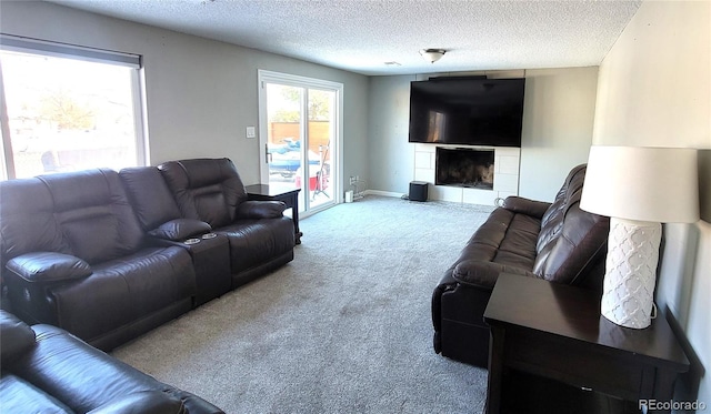 living area featuring light carpet, a textured ceiling, a fireplace, and baseboards