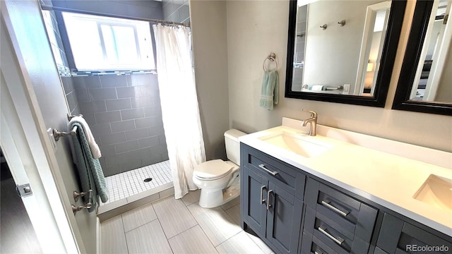 full bathroom featuring a stall shower, a sink, toilet, and double vanity