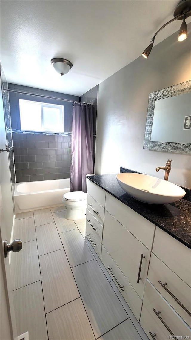 bathroom featuring toilet, shower / bath combination with curtain, and vanity