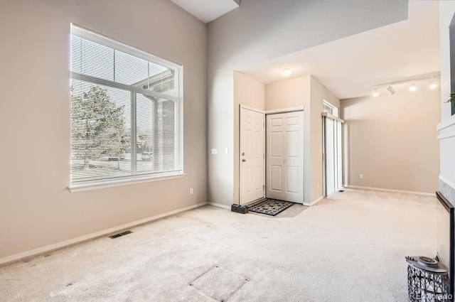 foyer entrance featuring rail lighting and light carpet