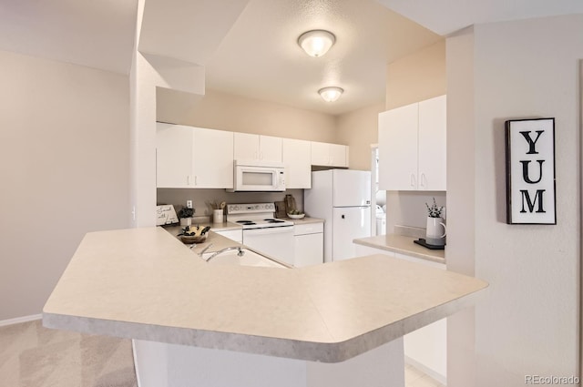 kitchen with sink, white cabinetry, light carpet, kitchen peninsula, and white appliances