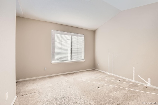 unfurnished room featuring vaulted ceiling and light colored carpet