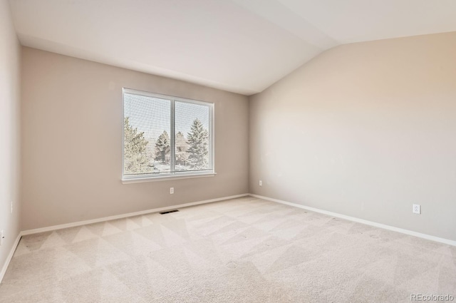 carpeted empty room with vaulted ceiling