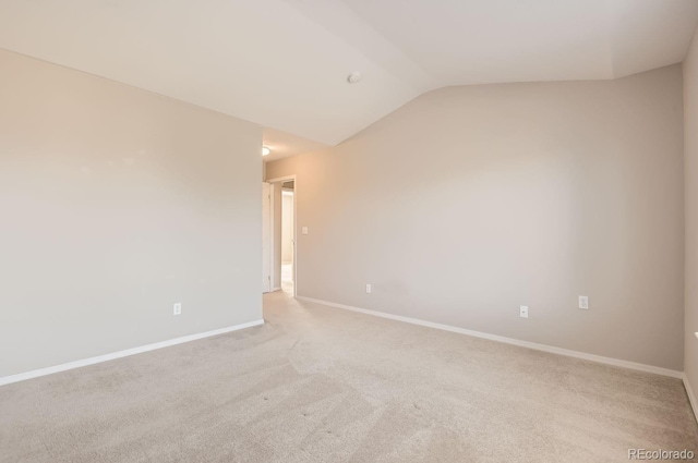 carpeted spare room featuring lofted ceiling