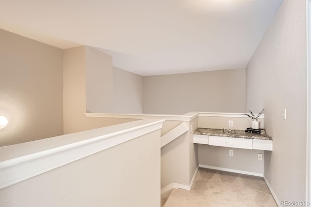 interior space with light colored carpet and built in desk