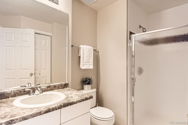 bathroom featuring vanity, toilet, and a shower with door