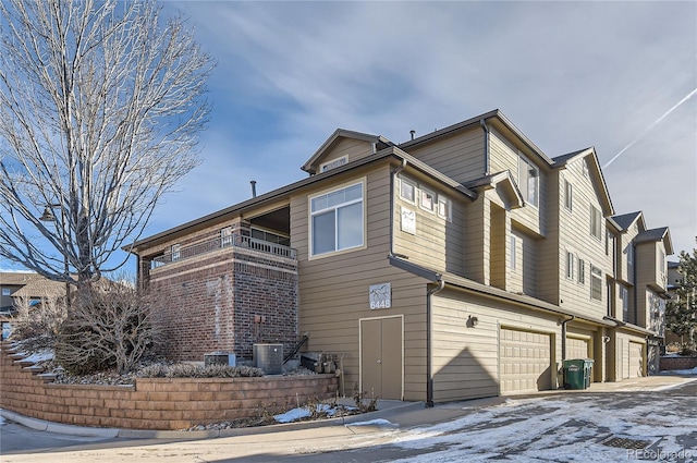 view of snowy exterior featuring a garage