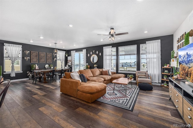 living room with a healthy amount of sunlight, ceiling fan, and dark wood-type flooring