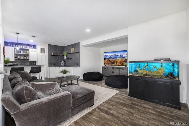 living room with bar area and dark wood-type flooring