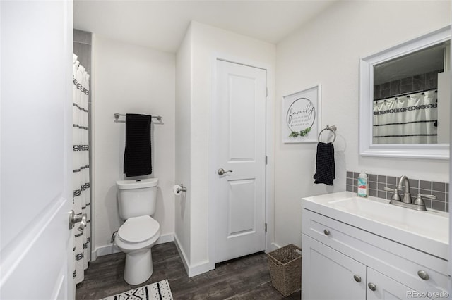 bathroom with vanity, toilet, backsplash, and hardwood / wood-style flooring