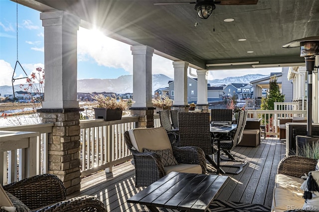 wooden deck with a mountain view and ceiling fan