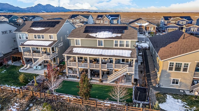 rear view of property featuring a mountain view, solar panels, and cooling unit