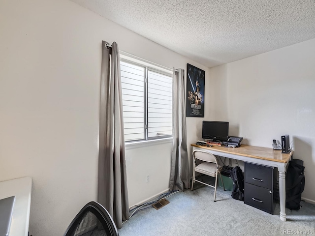 carpeted office space featuring a textured ceiling