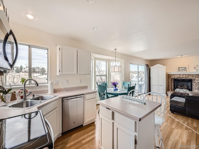 kitchen with pendant lighting, white cabinetry, appliances with stainless steel finishes, and sink