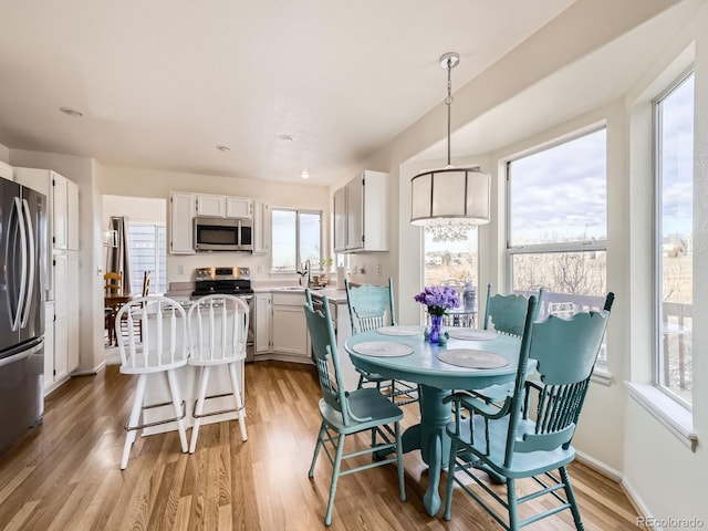 dining space with sink and light hardwood / wood-style floors