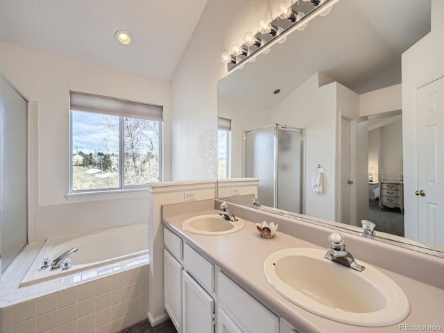 bathroom with vanity, lofted ceiling, and independent shower and bath