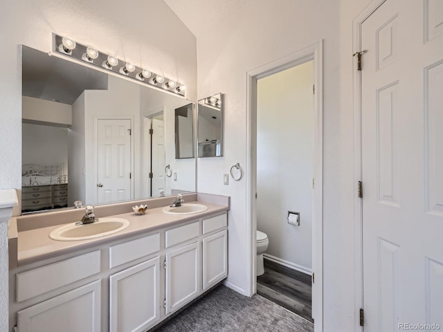 bathroom featuring vanity, wood-type flooring, and toilet