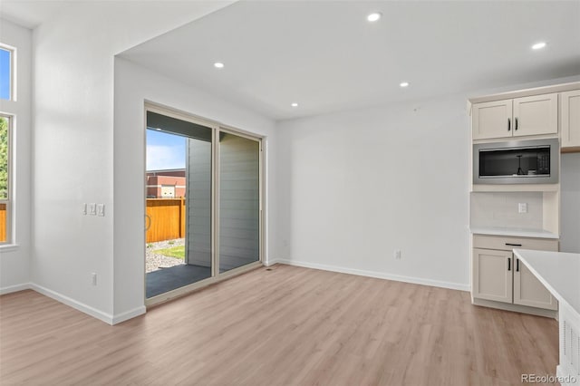 11341 W Alder Dr, Littleton, CO 80127 - unfurnished living room with light wood finished floors and recessed lighting
