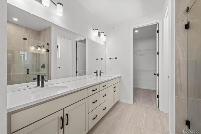 11341 W Alder Dr, Littleton, CO 80127 - full bathroom featuring a shower stall, double vanity, a spacious closet, tile patterned floors, and recessed lighting