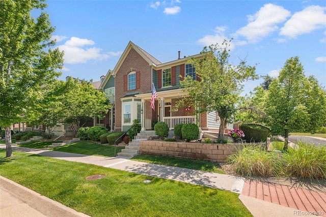 8318 Devinney Ct, Arvada, CO 80005 - view of front facade featuring brick siding, a front yard, and covered porch
