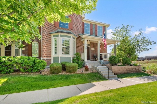 8318 Devinney Ct, Arvada, CO 80005 - view of front of property featuring brick siding, covered porch, and a front lawn
