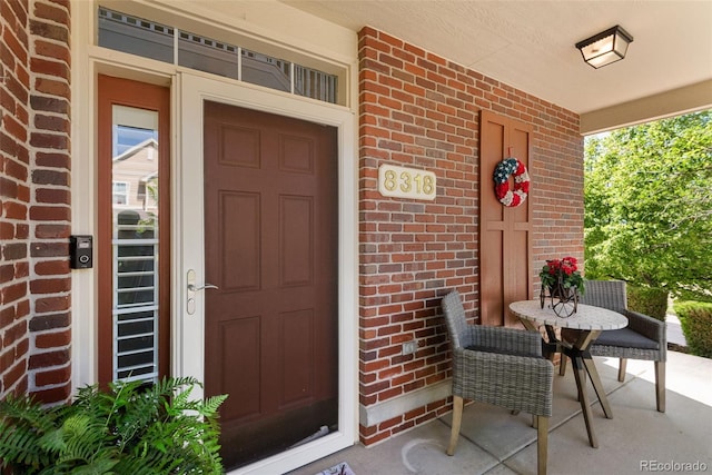8318 Devinney Ct, Arvada, CO 80005 - entrance to property featuring covered porch and brick siding