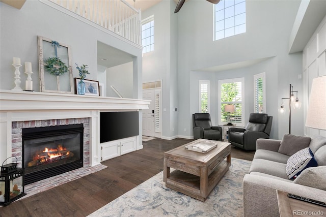 8318 Devinney Ct, Arvada, CO 80005 - living room with dark wood-style flooring, a towering ceiling, a brick fireplace, plenty of natural light, and a ceiling fan