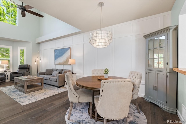 8318 Devinney Ct, Arvada, CO 80005 - dining space with ceiling fan, dark wood-style floors, a decorative wall, and a towering ceiling