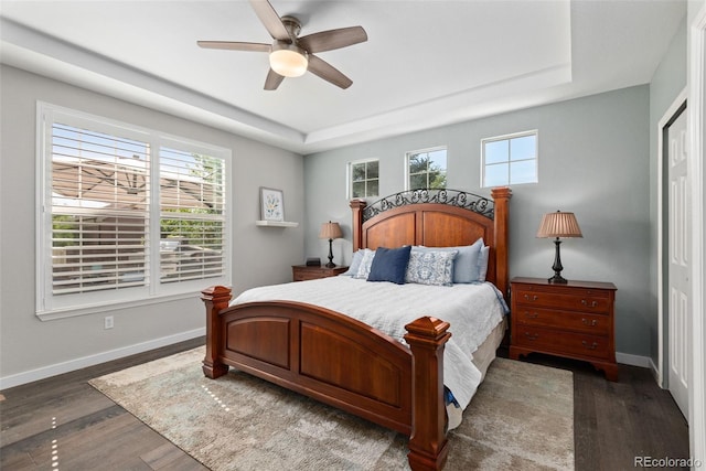 8318 Devinney Ct, Arvada, CO 80005 - bedroom featuring a tray ceiling, wood finished floors, and a ceiling fan