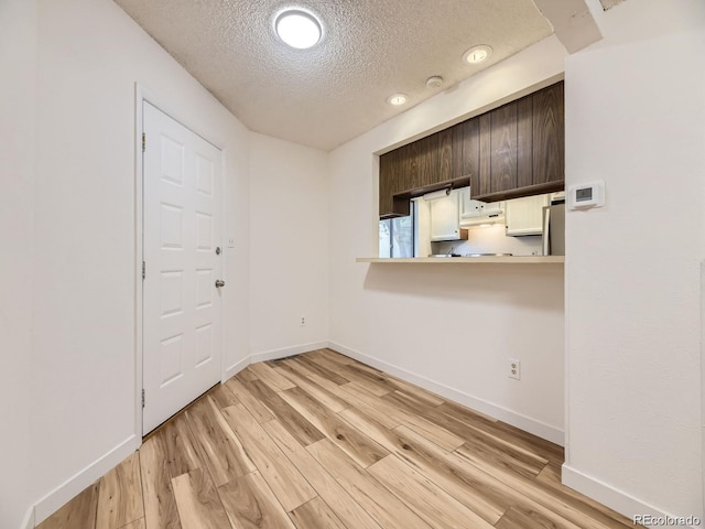 interior space featuring a textured ceiling and light wood-type flooring