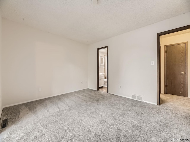 carpeted empty room with a textured ceiling