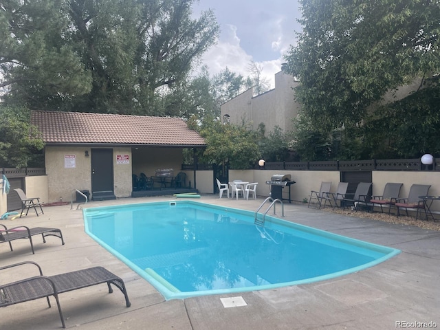 view of swimming pool with area for grilling, an outdoor bar, and a patio