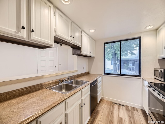 kitchen featuring sink, stainless steel appliances, white cabinets, and light wood-type flooring