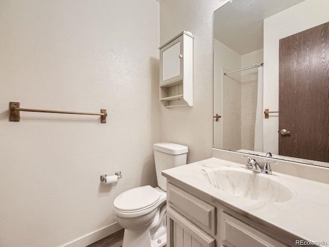 bathroom with walk in shower, vanity, toilet, and wood-type flooring