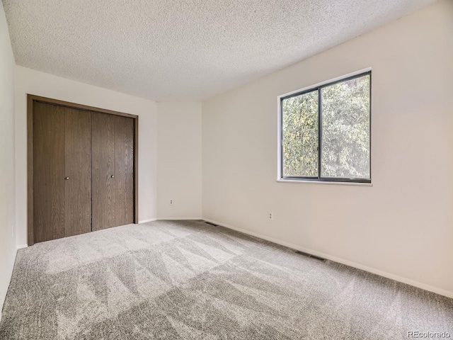 unfurnished bedroom with a closet, a textured ceiling, and carpet