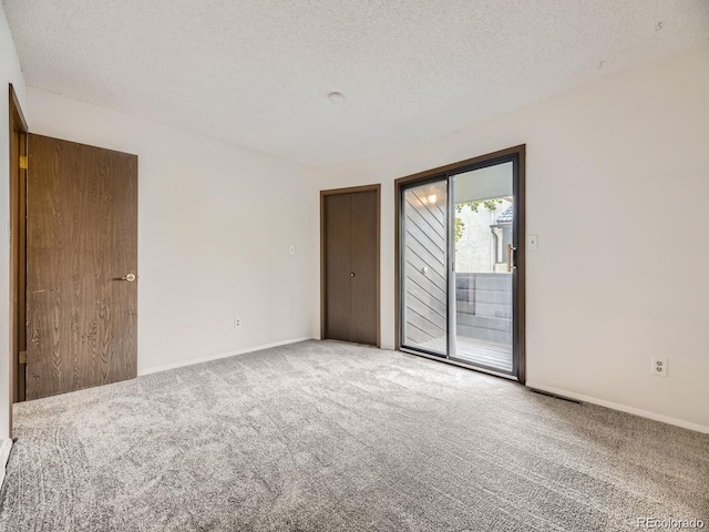 unfurnished room featuring carpet and a textured ceiling