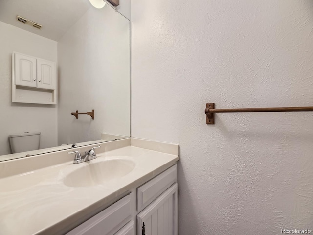 bathroom featuring vanity and toilet