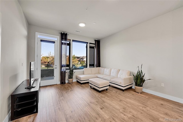 living area featuring baseboards, visible vents, and light wood-style flooring