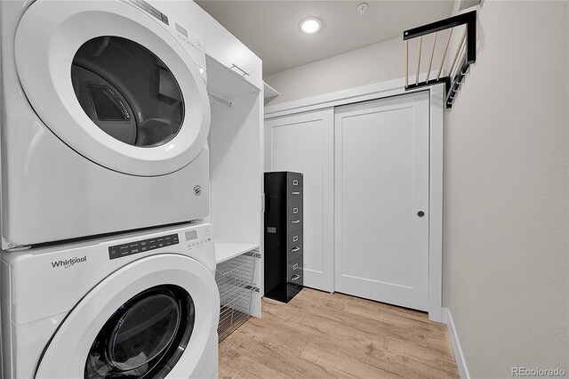 laundry area featuring recessed lighting, laundry area, stacked washing maching and dryer, and light wood finished floors