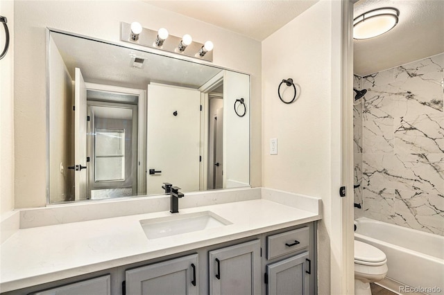 full bathroom with tiled shower / bath combo, vanity, and toilet