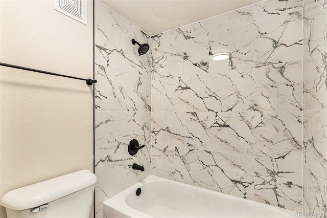 bathroom featuring toilet and tiled shower / bath combo