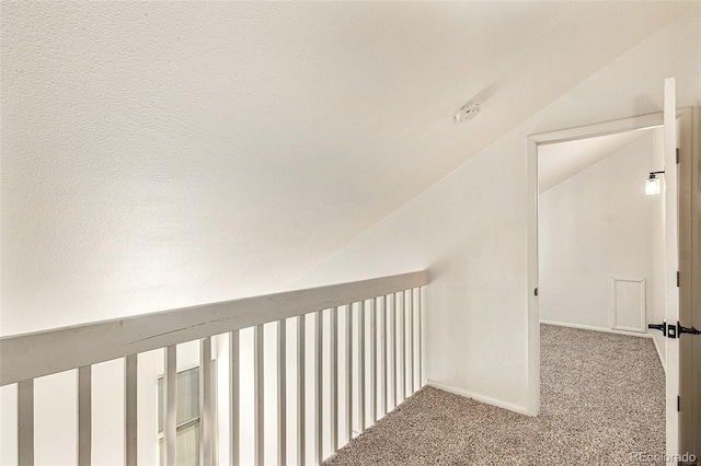 corridor featuring carpet flooring and vaulted ceiling