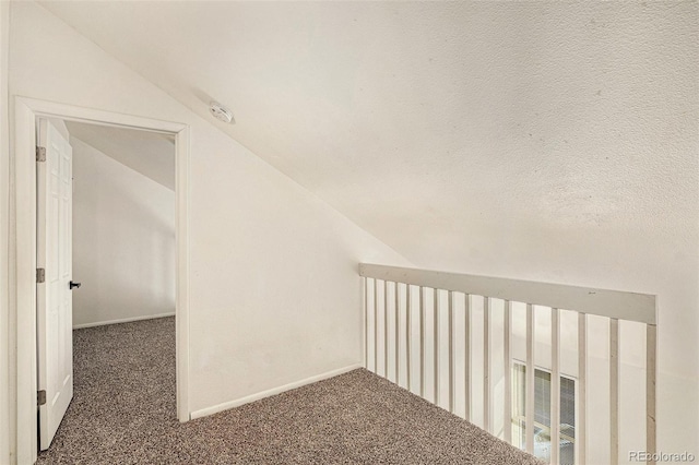 additional living space featuring lofted ceiling and dark carpet