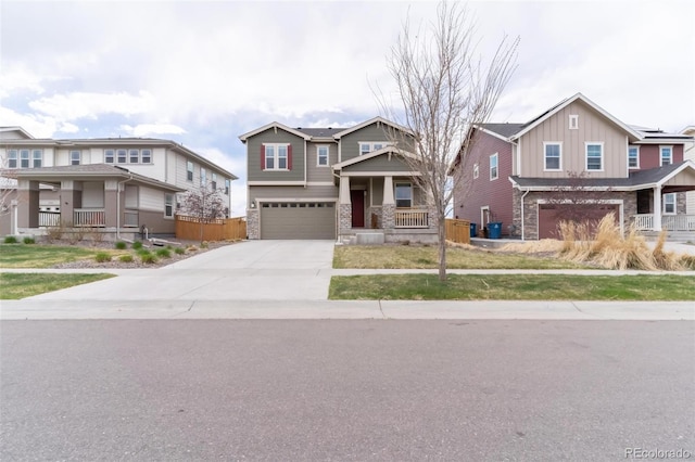 view of front of home featuring concrete driveway, stone siding, an attached garage, fence, and board and batten siding