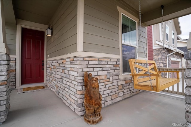 property entrance with stone siding and covered porch