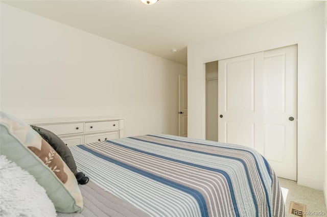 bedroom with light carpet and a closet