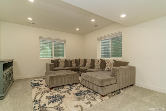 carpeted living area with a wealth of natural light, recessed lighting, visible vents, and baseboards