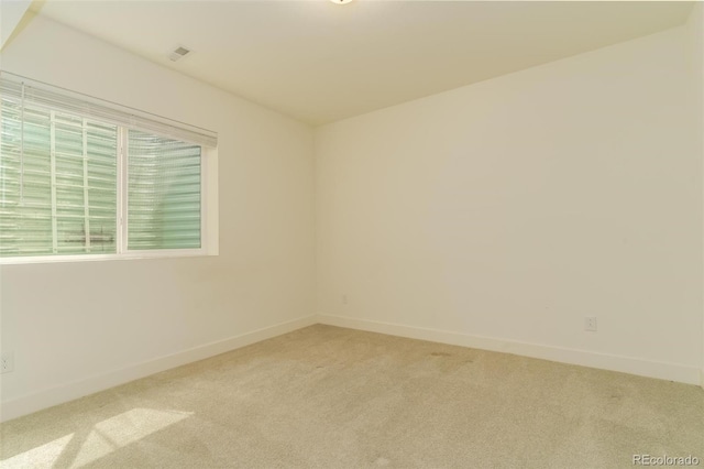 carpeted spare room featuring baseboards