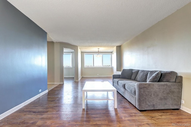 living room featuring a textured ceiling and dark hardwood / wood-style flooring